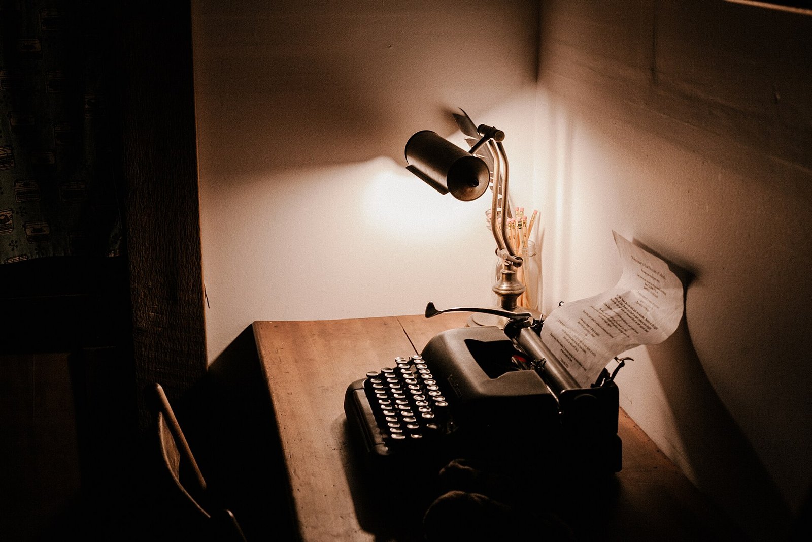 Máquina de escrever sob luz de luminária, representando textos escritos por humanos e por IA