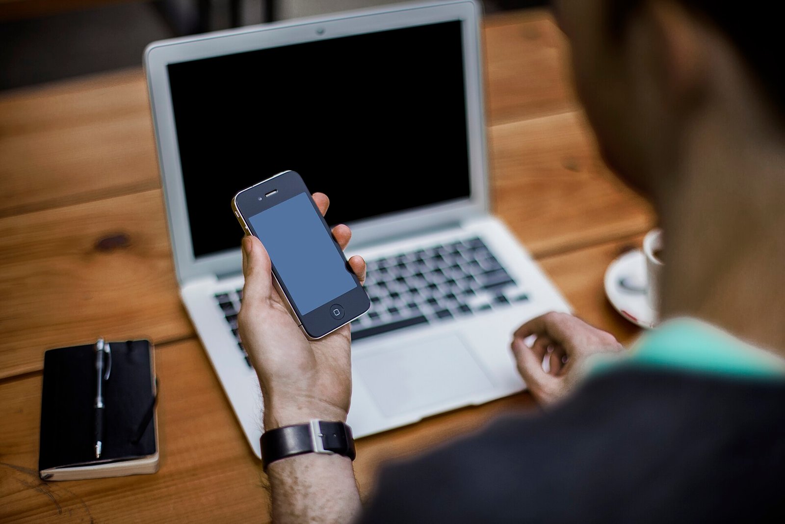 Pessoa usando smartphone e notebook para usar inteligência artificial no dia a dia